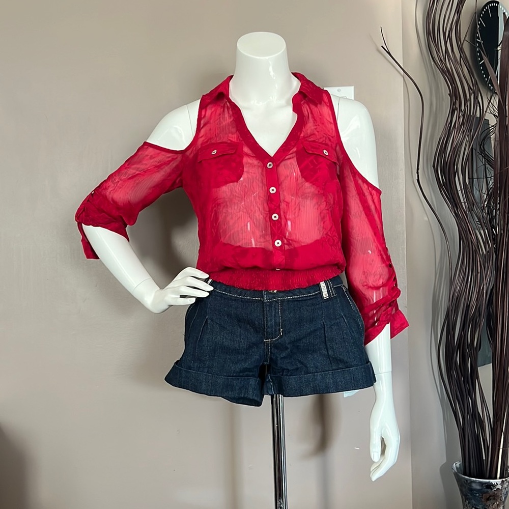 Red V neck, shoulder less button down blouse paired with  Denim shorts